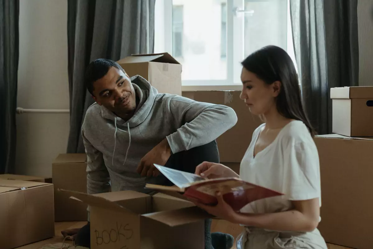 Paar plant den Umzug zwischen gepackten Kartons im Wohnzimmer