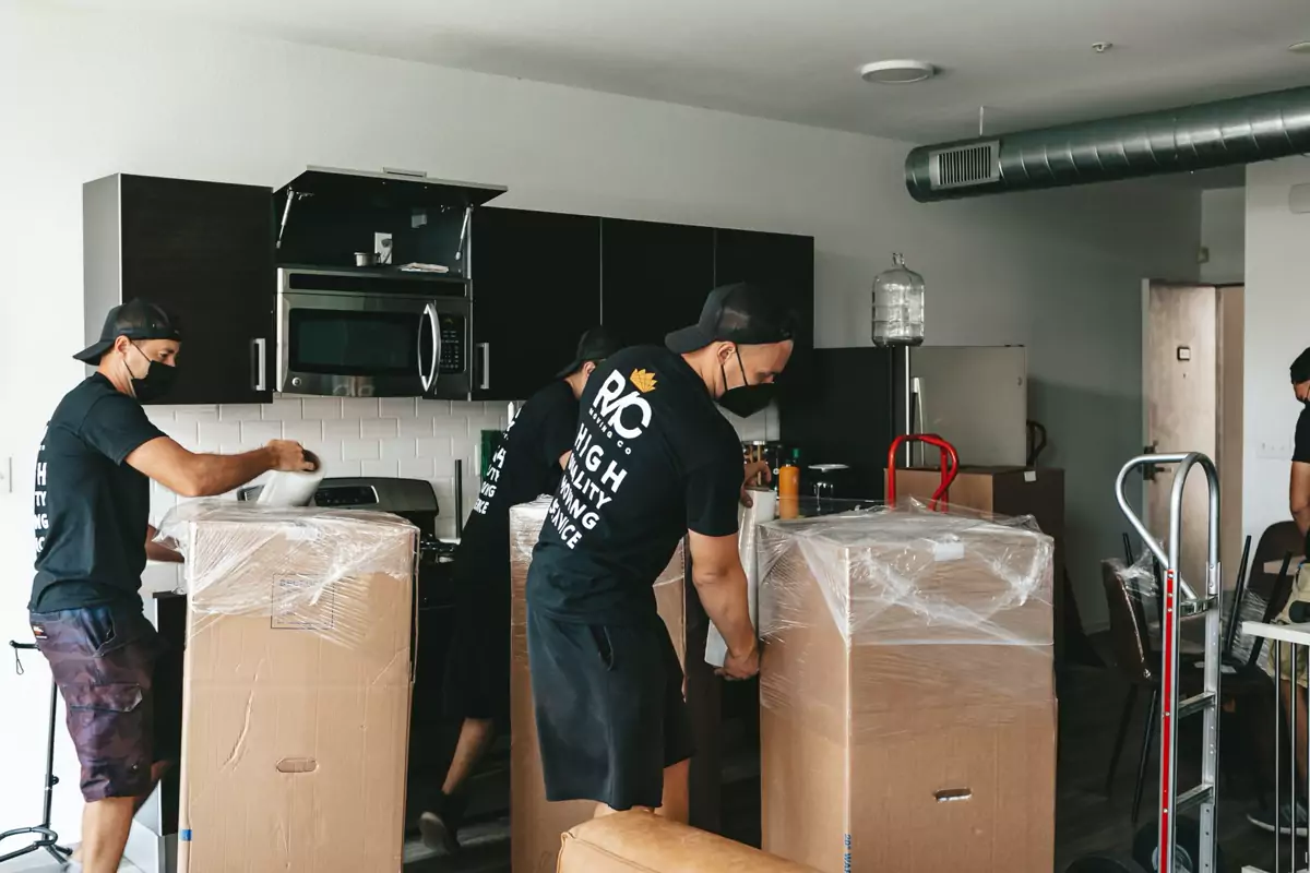 Umzugshelfer sichern verpackte Möbel in einer Wohnung
