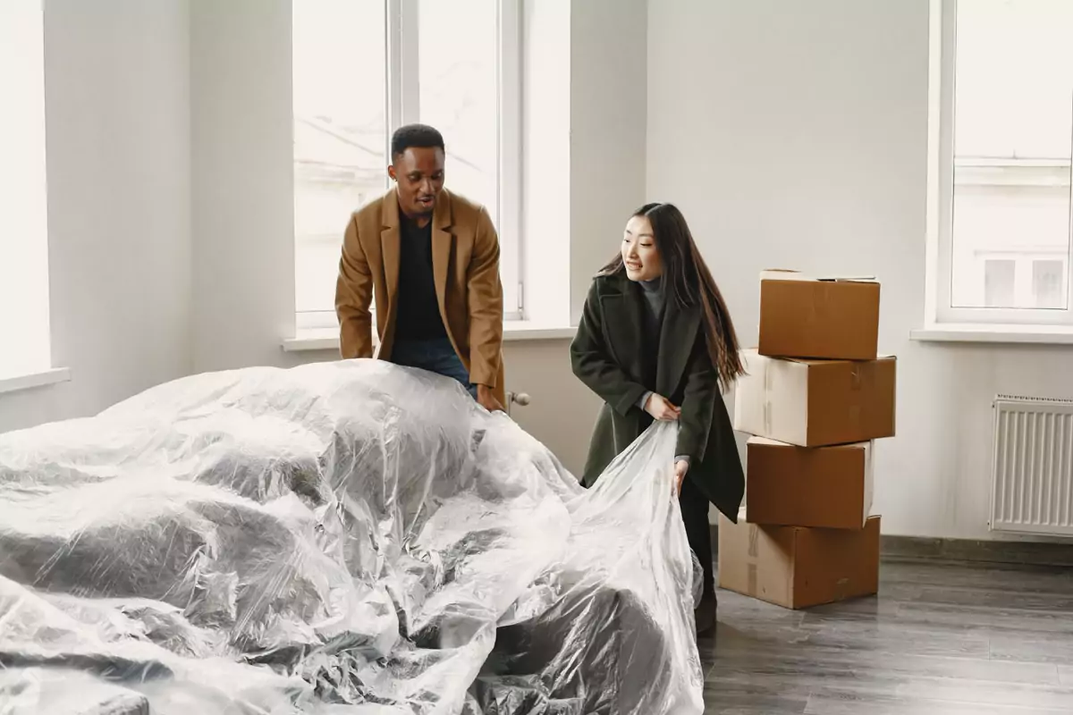 Umzugshelfer bereiten Kartons im neuen Schlafzimmer vor
