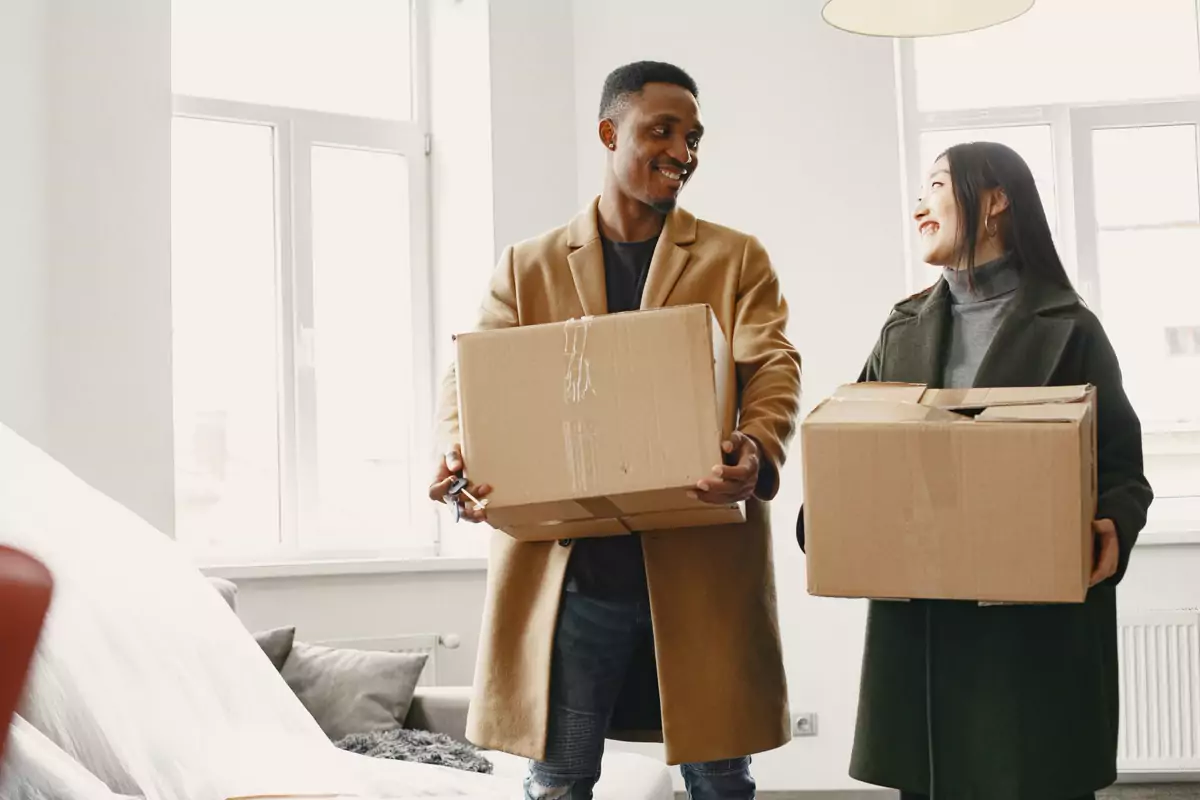 Zwei Personen halten fertig gepackte Kartons zur Übergabe bereit