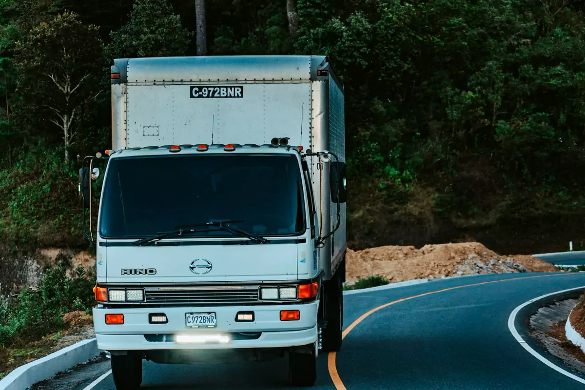 Koffer-Lkw fährt auf einer kurvigen Landstraße zum Zielort