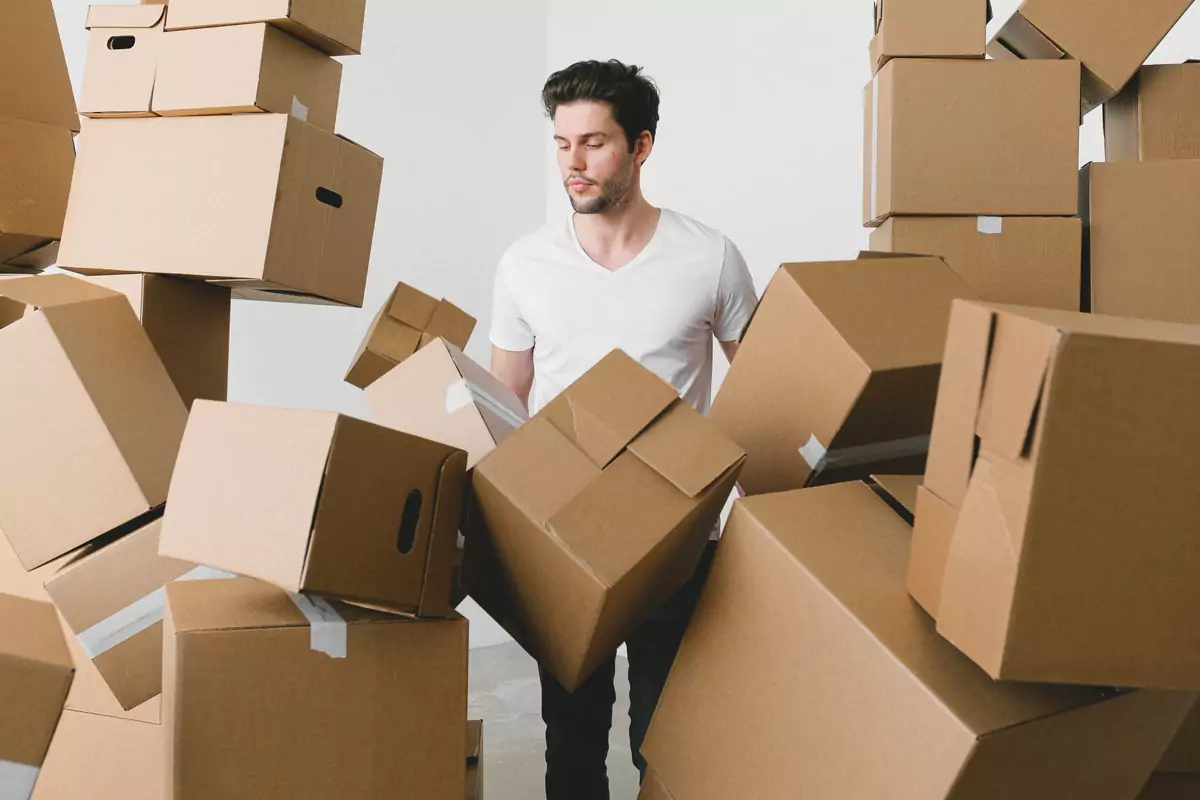 Mann sortiert leere Kartons für das Verpacken des Hausrats